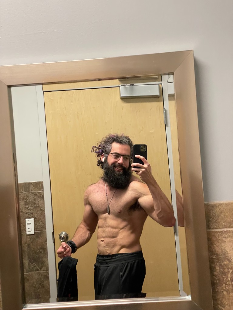 Ian mirror selfie showing abs and arm definition